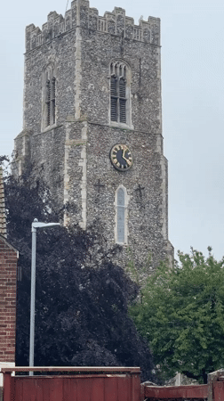 Stone church tower with gold clock documented in Great Yarmouth
