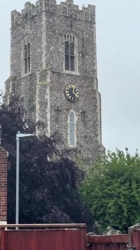 Stone church tower with gold clock documented in Great Yarmouth