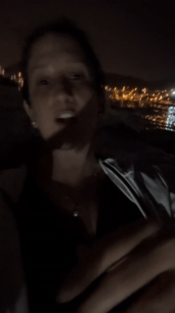 Woman films nighttime selfie videos along Ancón Peru coastline