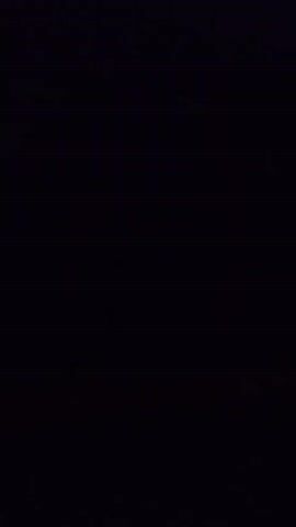 A nighttime video taken from a moving vehicle shows streaks of light on the right side of the frame, indicating passing headlights or taillights of other vehicles. The rest of the frame is dark.