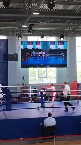 Boxing match between blue and red competitors in Kopeysk arena
