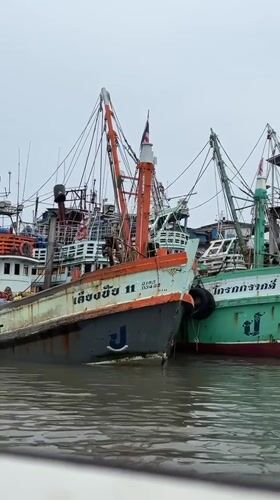 Fishing boats moored at Ratsada harbor under gray skies