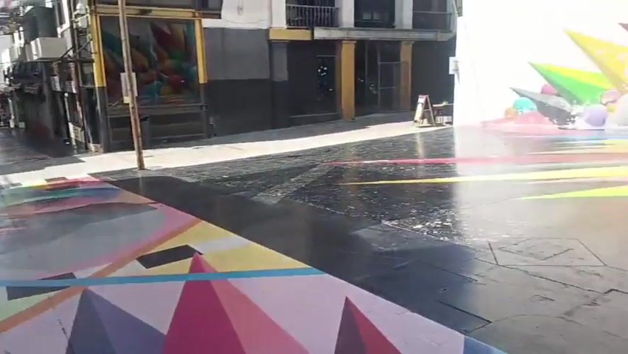 Pedestrian passes vibrant geometric street art in Spanish town