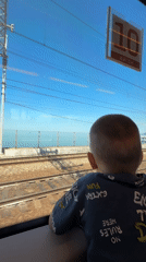 Child watches scenery from train window in Sochi