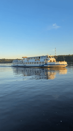 Woman films boat selfie during sunset in Rusanovo