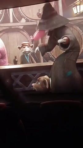 The video shows a movie playing on a screen, likely in a theater. The scene features anthropomorphic mice dressed in formal attire. In the foreground, a mouse in a pink jacket and a hat confronts another mouse dressed in a trench coat and hat who is falling or leaning awkwardly. In the background, a group of mice are stacked on top of each other. The camera is angled upwards towards the screen, and the bottom portion of the image is dark, suggesting the presence of seats in front of the screen. The movie appears to be animated, with a stylized, slightly cartoonish aesthetic.