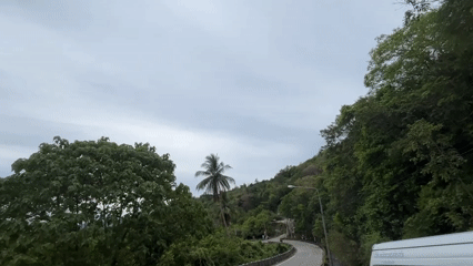 Motorcycle journey through lush tropical hillside roads in Thailand