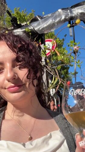 Woman enjoys wine outdoors in sunny Amsterdam afternoon