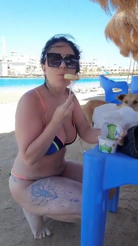 Woman enjoys beachside snack in Hurghada, Egypt
