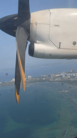 Passenger films turboprop engine view during flight over Philippines