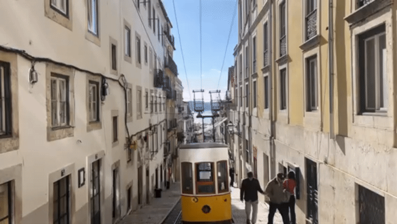 Lisbon's iconic yellow funicular spotted descending Bica street
