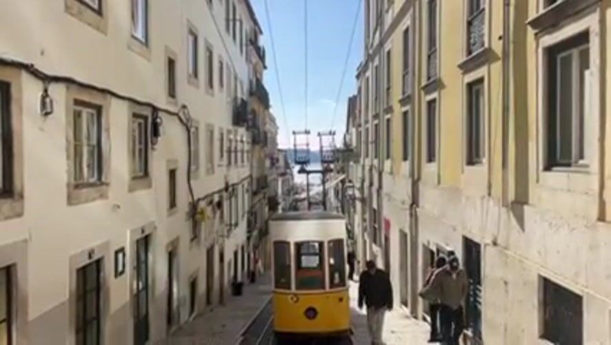 Lisbon's iconic yellow funicular spotted descending Bica street