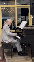 Grey-haired pianist performs on grand piano in Serik, Turkey