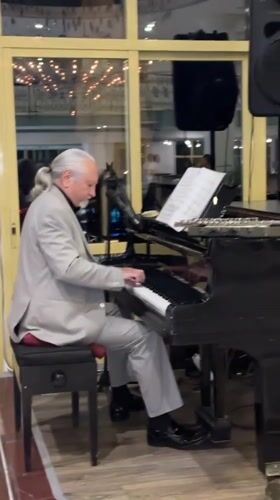 Grey-haired pianist performs on grand piano in Serik, Turkey