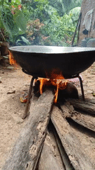 Open-fire cooking with wok and coconut husks, Lhokseumawe