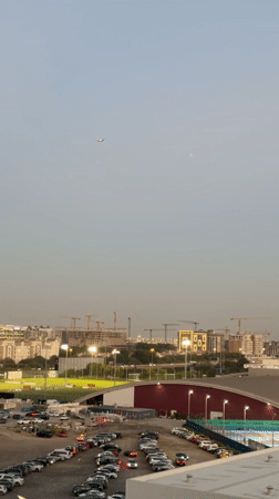 Dubai skyline shows ongoing construction with soccer field foreground