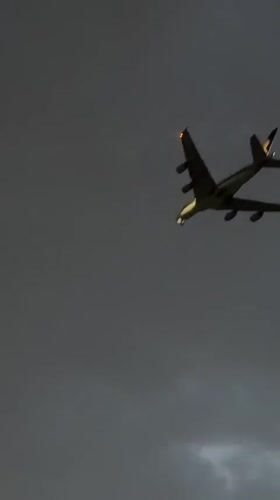 Aircraft spotted through cloudy skies over Delhi rooftops