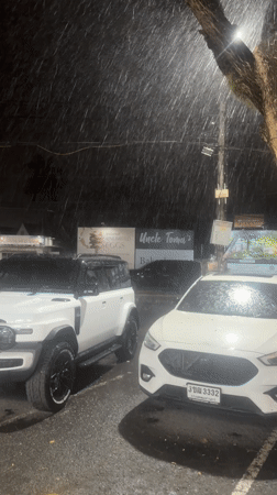 Rainy street scene and musical performance documented in Thailand