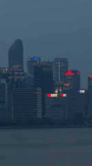 Illuminated skyline observed across water in Shangcheng District