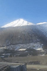 Snow-capped mountain oversees industrial construction in Almasiani, Georgia