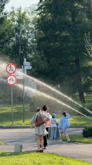 Municipal tractor waters green space as residents watch