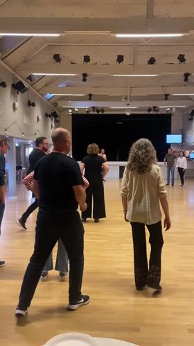 Middle-aged couples enjoy line dancing in Uppsala hall