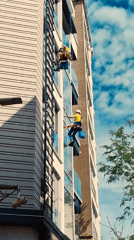 Window washers clean tall building exterior in Budva, Montenegro