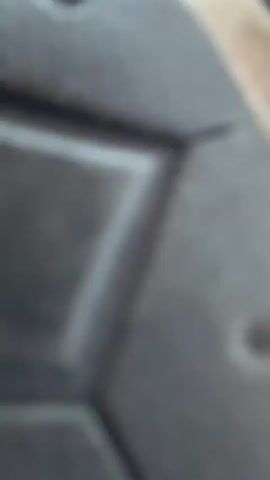 The video shows a person with long, dark hair and a striped long-sleeved shirt. The person is in motion, with their hair flying around their head. The camera appears to be positioned below the person, looking up at them against a bright, cloudy sky. The person's face is visible, and they appear to be looking towards the camera. The video captures a moment of energetic movement, possibly dancing or playing.