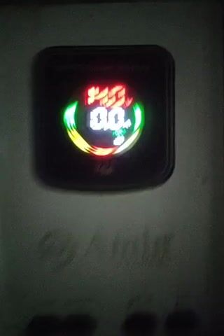 This is a close-up video of a digital display on a black electronic device, likely a solar charge controller given the "MPPT Smart Display" text. The display shows a voltage of "14.0V" in red at the top, and "0.0A" in white below it. A green indicator labeled "FULL" with a battery icon is also visible. A circular graphic surrounds the voltage and amperage readings, with segments of green, yellow, and red light. The device is mounted on a textured surface, possibly a wall or panel. The lighting is dim, and the overall impression is of an active but currently inactive electronic device.