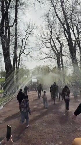 Families play in Peterhof fountain sprays on spring day