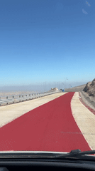 Vehicle travels red-painted road section near Arica, Chile