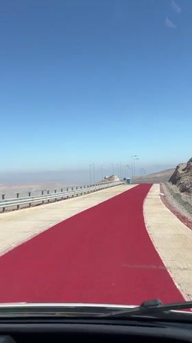 Vehicle travels red-painted road section near Arica, Chile