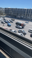 Tbilisi street traffic, one stalled sedan with hood up