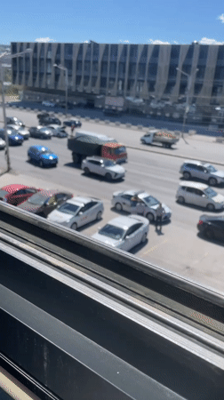 Tbilisi street traffic, one stalled sedan with hood up