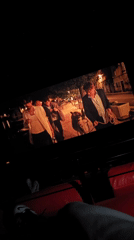 Moviegoer watches film with waterfront, neon room scenes