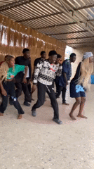 Young dancers practice choreographed routines in covered outdoor space