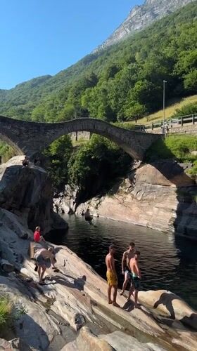 Summer afternoon at Verzasca's emerald river and stone bridge