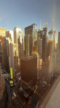 Times Square skyscrapers captured through window at night