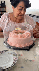 Woman enjoys pink cake at table in Puebla