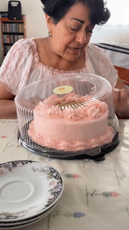 Woman enjoys pink cake at table in Puebla