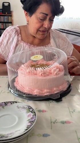 Woman enjoys pink cake at table in Puebla