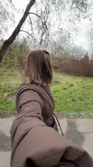 Woman walks through park in Reshetnikovo, Russia