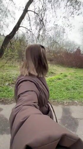 Woman walks through park in Reshetnikovo, Russia