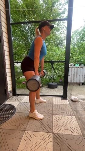 Morning barbell workout session on outdoor patio in Baranovka