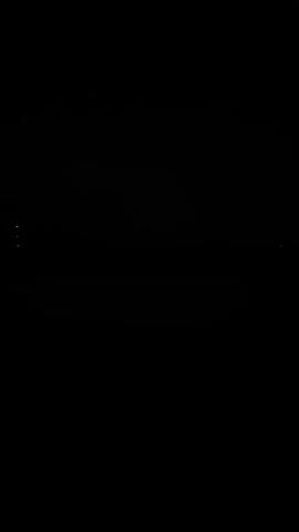 A black screen transitions to a shot of the moon in the night sky, partially obscured by clouds, above a dark silhouetted treeline. There is a faint reflection of light on the water in the foreground.