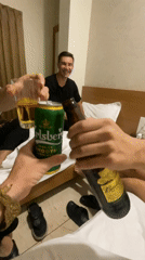 Three men toast drinks in Kolhapur hotel room
