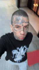 Tattooed man films selfie near historical murals in Buenos Aires