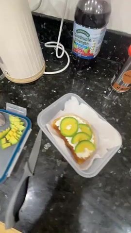 The video begins by showing a kitchen counter with a kettle, a bottle of soda, a container of chopped avocado, a slice of toast with cream cheese and avocado, and a knife. The camera then pans to show a toaster and a package of bread. Next, the video shows a pot of eggs boiling on a stovetop. Finally, the video shows a person's arm, which appears to be red and possibly burned or irritated. The person's arm is shown in front of the kitchen counter with the toaster and bread in the background. The environment appears to be a home kitchen.