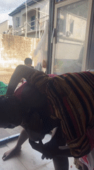 Two women socialize and dance in small Nigerian convenience store