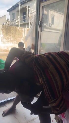 Two women socialize and dance in small Nigerian convenience store